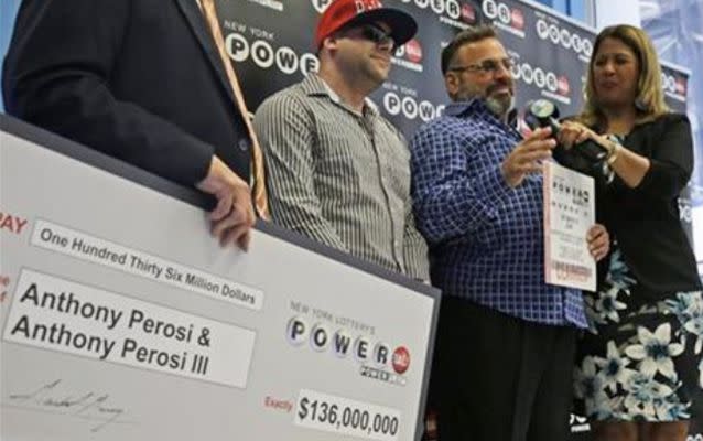 Anthony Perosi, second from right, holding a copy of the winning power ball ticket and his so Anthony Perosi III, second from left,  were presented with an oversized check on Thursday. Photo: AP/ Mary Altaffer.