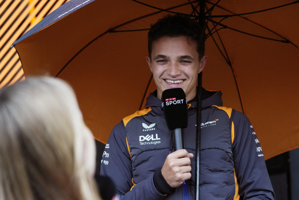 McLaren driver Lando Norris of Britain speaks with a journalist as he arrives in the paddock at the Dino and Enzo Ferrari racetrack, in Imola, Italy, Thursday, April 21, 2022. Italy's Emila Romagna Formula One Grand Prix will take place on Sunday. (AP Photo/Luca Bruno)