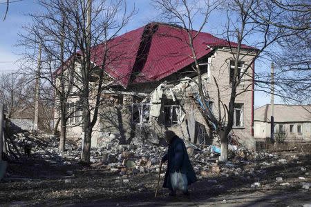 Woman walks past a house which was damaged by fighting in the town of Debaltseve February 25, 2015. REUTERS/Baz Ratner