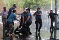 Demonstrators react as police try to detain one of them during a protest against the replacement of Kurdish mayors with state officials in three cities, in Diyarbakir