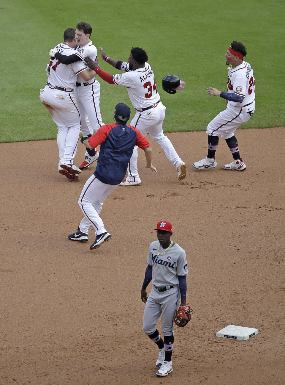 Atlanta Braves' Max Fried, second from top left, is mobbed by teammates after making the winning hit against the Miami Marlins during the 10th inning of a baseball game Sunday, July 4, 2021, in Atlanta. (AP Photo/Ben Margot)