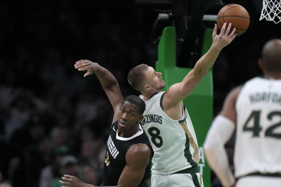 Boston Celtics center Kristaps Porzingis (8) shoots at the basket as Memphis Grizzlies center Trey Jemison (55) defends in the first half of an NBA basketball game, Sunday, Feb. 4, 2024, in Boston. (AP Photo/Steven Senne)