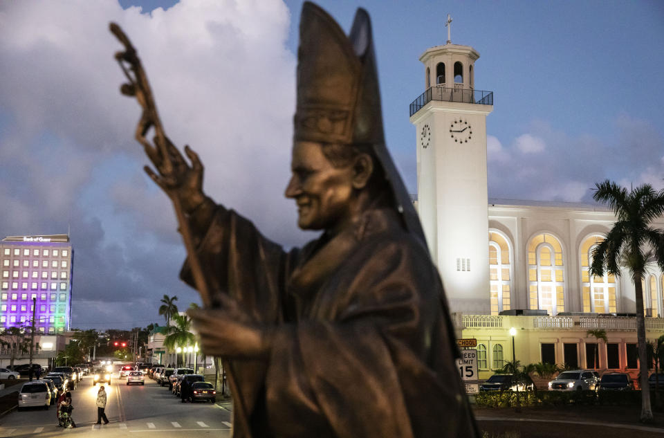 FILE - A statue of Pope John Paul II stands outside the island's main cathedral, Dulce Nombre de Maria Cathedral-Basilica, during a Mass in Hagatna, Guam, on May 7, 2019. The powerful Pacific typhoon Mawar that lashed of Guam on Thursday, May 25, 2023, with damaging high winds, heavy rains and a dangerous storm surge arrived as the worst storm in decades, interrupting life for residents and the U.S. military on a tropical island that is the easternmost of the nation's territories. (AP Photo/David Goldman, File)