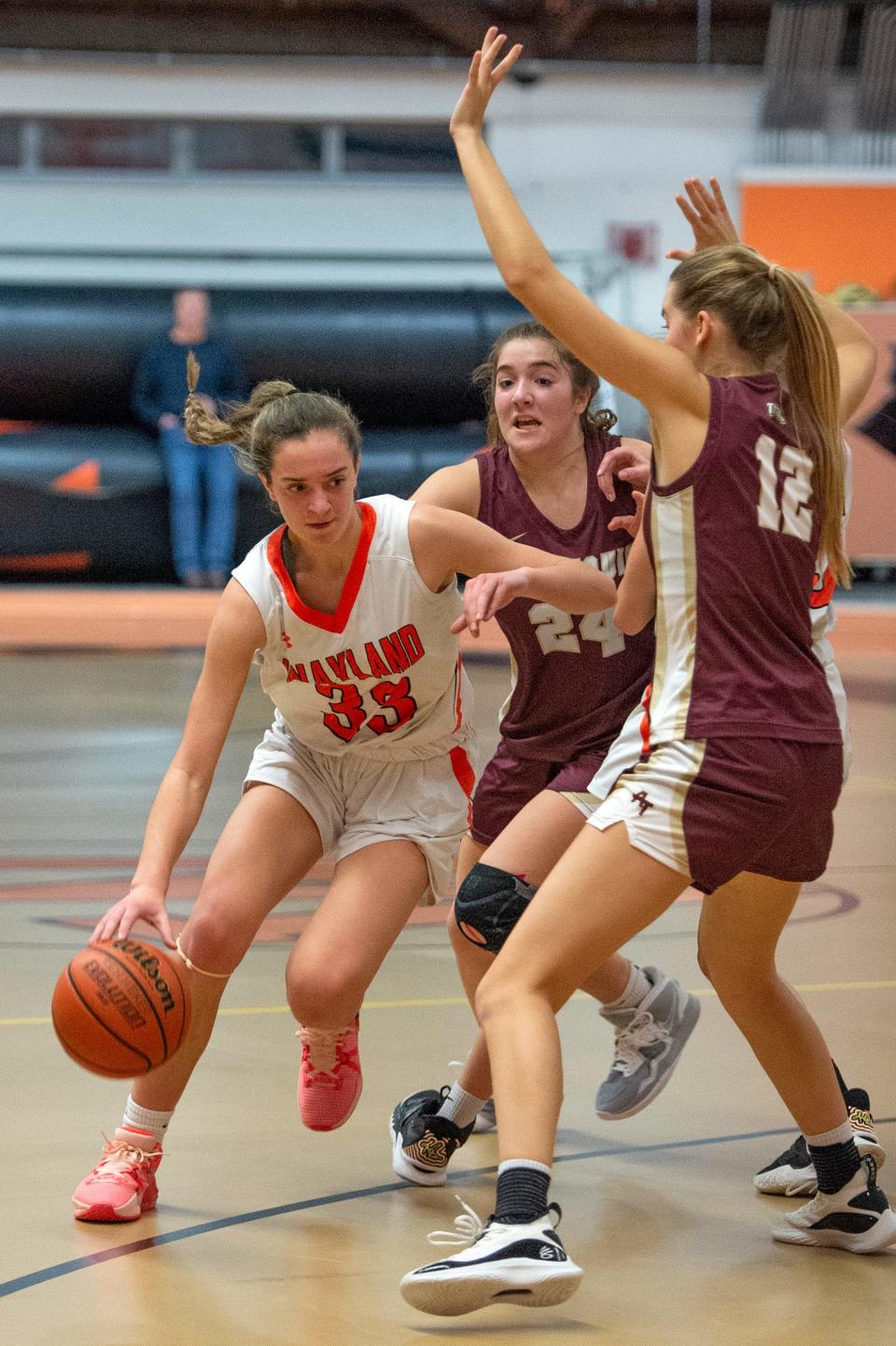 Wayland freshman Ella Getz gets around Algonquin defenders during the game at Wayland High, Dec. 22, 2022. The Warriors beat the Titans, 45-37.