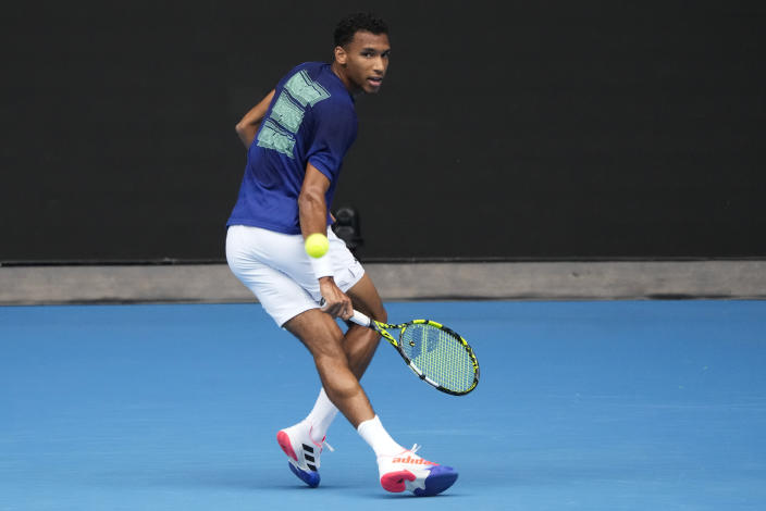 Canada's Felix Auger-Aliassime plays a backhand return to Spain's Rafael Nadal during a practice session on Rod Laver Arena ahead of the Australian Open tennis championship in Melbourne, Australia, Friday, Jan. 13, 2023. (AP Photo/Mark Baker)