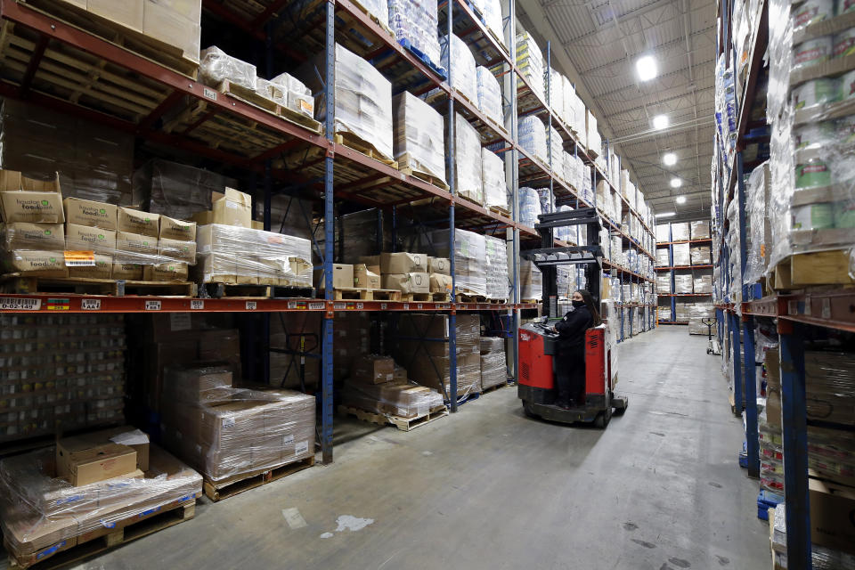 Fork lift driver Linda Rodriguez repositions pallets of boxed foods within the extensive warehouse at the Houston Food Bank Wednesday, Oct. 14, 2020, in Houston. “Food banks and food pantries are doing great work,” says Luis Guardia, president of the Food Research & Action Center, a nonprofit organization. “But they simply cannot do enough to be something of the order of magnitude that we’re seeing right now. (AP Photo/Michael Wyke)