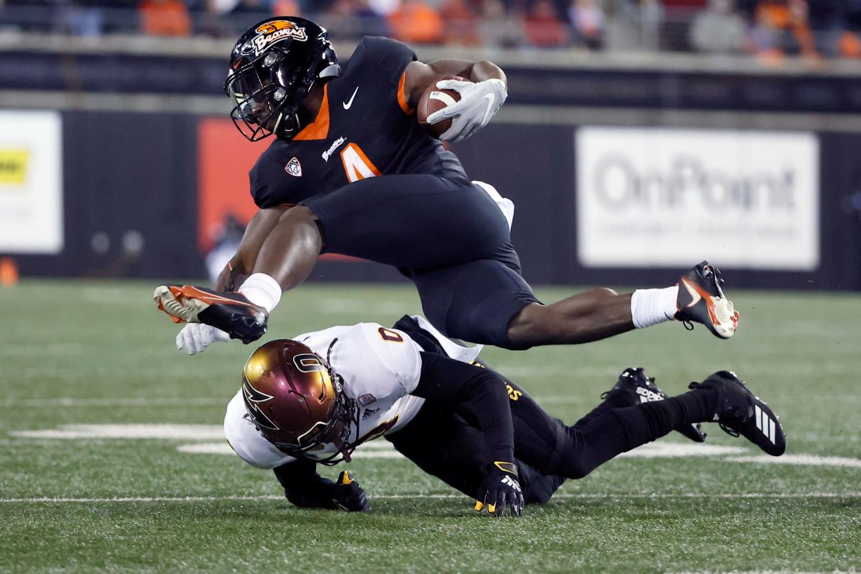 Oregon State Beavers running back B.J. Baylor (4) is tackled by Arizona State Sun Devils defensive back Jack Jones (0) during the first half at Reser Stadium during a game on Nov. 20, 2021.