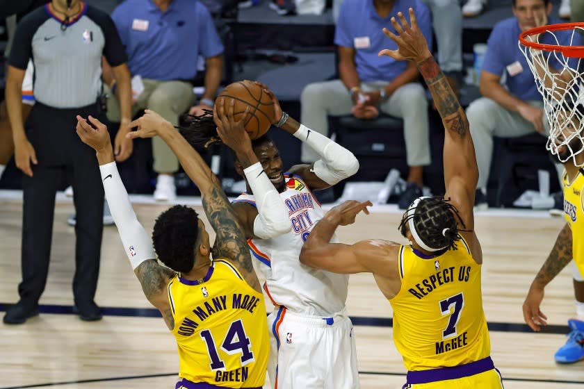 Oklahoma City Thunder's Nerlens Noel is defended by Los Angeles Lakers' Danny Green, left, and JaVale McGee during the second quarter of an NBA basketball game Wednesday, Aug. 5, 2020, in Lake Buena Vista, Fla. (Kevin C. Cox/Pool Photo via AP)