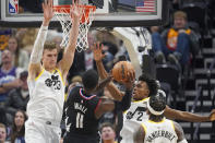 Los Angeles Clippers guard John Wall (11) shoots as Utah Jazz's Lauri Markkanen (23) and Collin Sexton (2) defend during the first half of an NBA basketball game Wednesday, Nov. 30, 2022, in Salt Lake City. (AP Photo/Rick Bowmer)