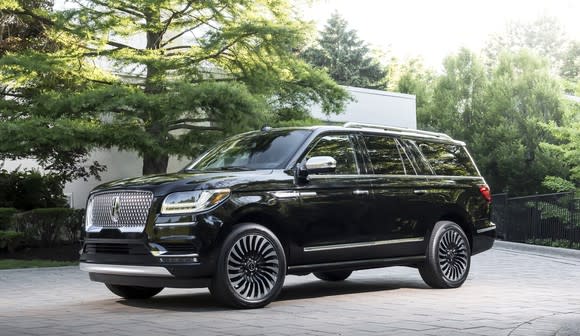 A black 2018 Lincoln Navigator, a large, truck-based luxury SUV with dramatic nautical-inspired styling, is shown on a country road.