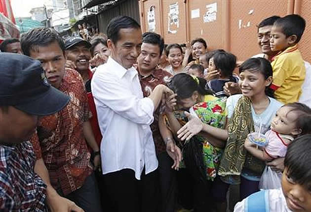 Jakarta's Governor Joko Widodo, also known as Jokowi, is greeted by residents during his visit to inspect the aftermath of a slum fire area in west Jakarta April 9, 2013. (REUTERS/Enny Nuraheni)