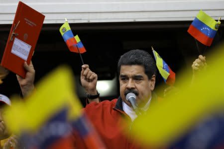 Venezuela's President Nicolas Maduro holds a document with the details of a