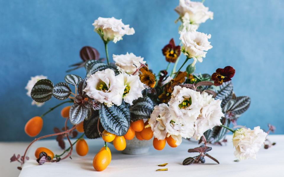 An arrangement with lisianthus, pilea, kumquat branch and Tiger Eyes pansies from Ikebana Unbound - M.K. Sadler