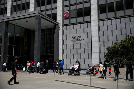 People wait outside the Phillip Burton Federal Building & United States Courthouse during a major power outage in San Francisco, California, U.S., April 21, 2017. REUTERS/Stephen Lam