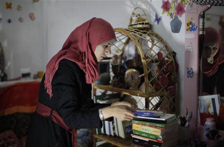 Isra Al-Modallal, a spokeswoman of the Hamas government in Gaza, prepares herself before heading to the office, at her house in Rafah refugee camp in the southern Gaza Strip November 10, 2013.REUTERS/Ibraheem Abu Mustafa