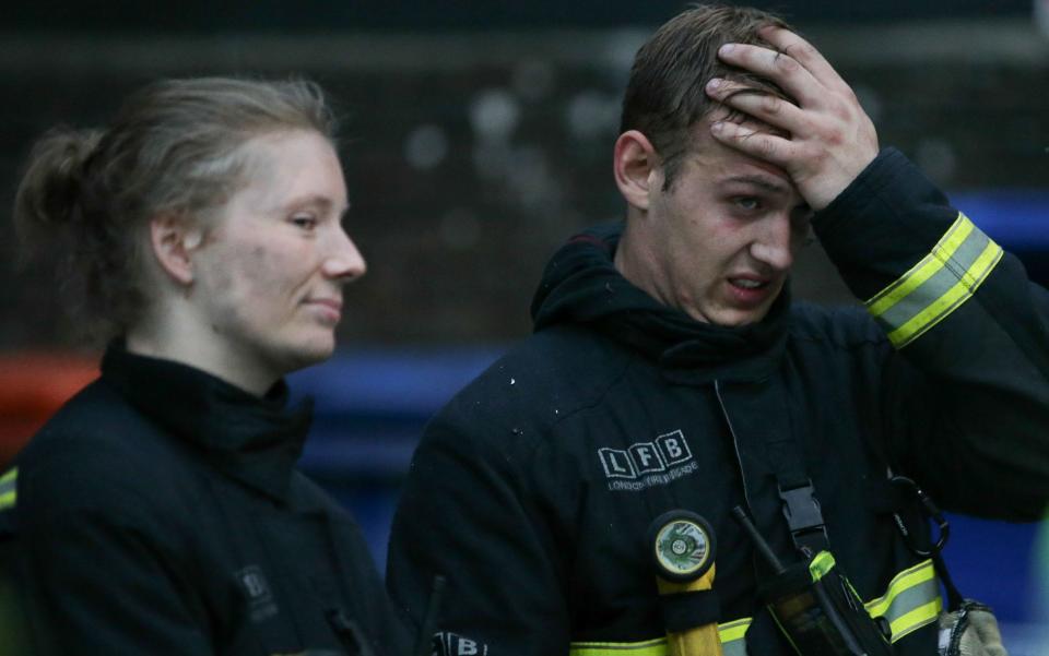 Two of the several hundred firefighters who dealt with the blaze - Credit: DANIEL LEAL-OLIVAS/AFP