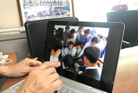 Yu-Taik Chon, president of Pyongyang University of Science and Technology (PUST), shows a picture of students attending a class in PUST, at his office in Seoul, South Korea, June 14, 2018. Picture taken on June 14, 2018. REUTERS/Park Ju-min