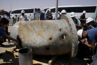 In this photo opportunity during a trip organized by Saudi information ministry, media film holes caused by fragments of a missile in a damaged pipe in the Aramco's Khurais oil field, Saudi Arabia, Friday, Sept. 20, 2019, after it was hit during Sept. 14 attack. Saudi officials brought journalists Friday to see the damage done in an attack the U.S. alleges Iran carried out. Iran denies that. Yemen's Houthi rebels claimed the assault. (AP Photo/Amr Nabil)