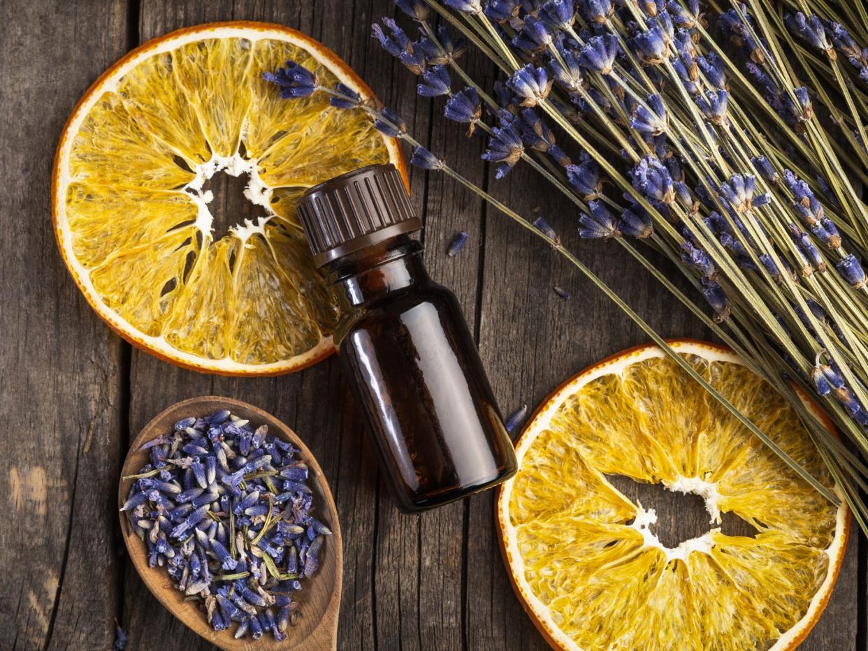 Essential oil lavender and orange dry on a wooden table, top view