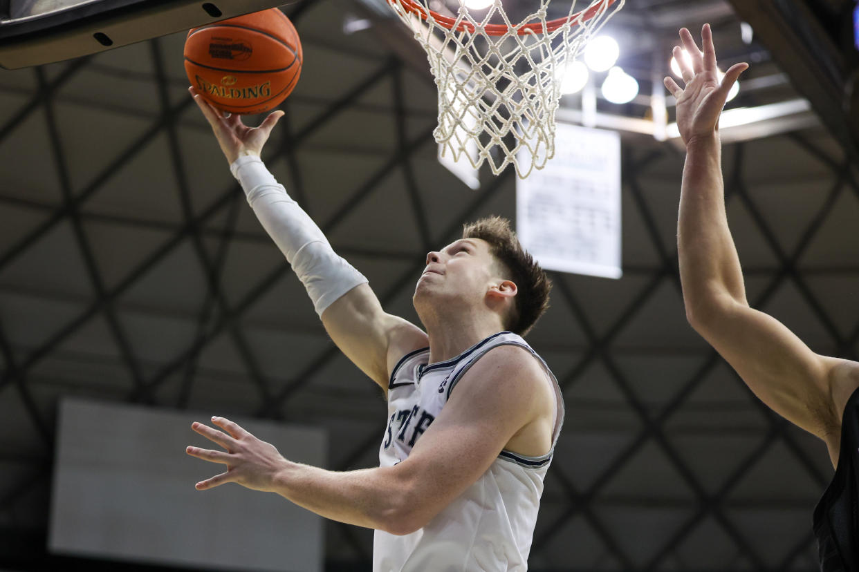 HONOLULU, HI - DECEMBER 22: Max Shulga #11 of the Utah State Aggies throws in a reverse layup during the first half the Hawaiian Airlines Diamond Head Classic game against the Seattle Redhawks at SimpliFi Arena on December 22, 2022 in Honolulu, Hawaii. (Photo by Darryl Oumi/Getty Images)