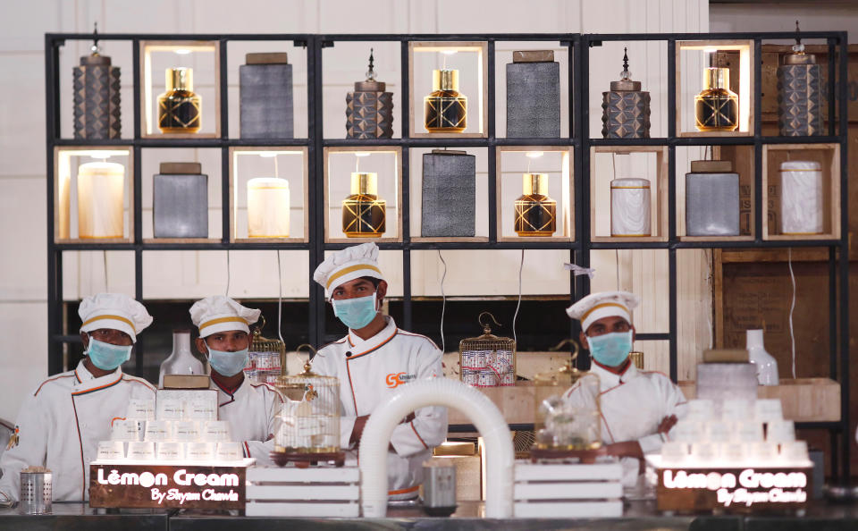 Catering staff wearing protective masks stands at an empty food counter at a wedding ceremony amidst an outbreak of the coronavirus disease (COVID-19) in New Delhi, India, March 21, 2020. Picture taken on March 21, 2020. REUTERS/Adnan Abidi