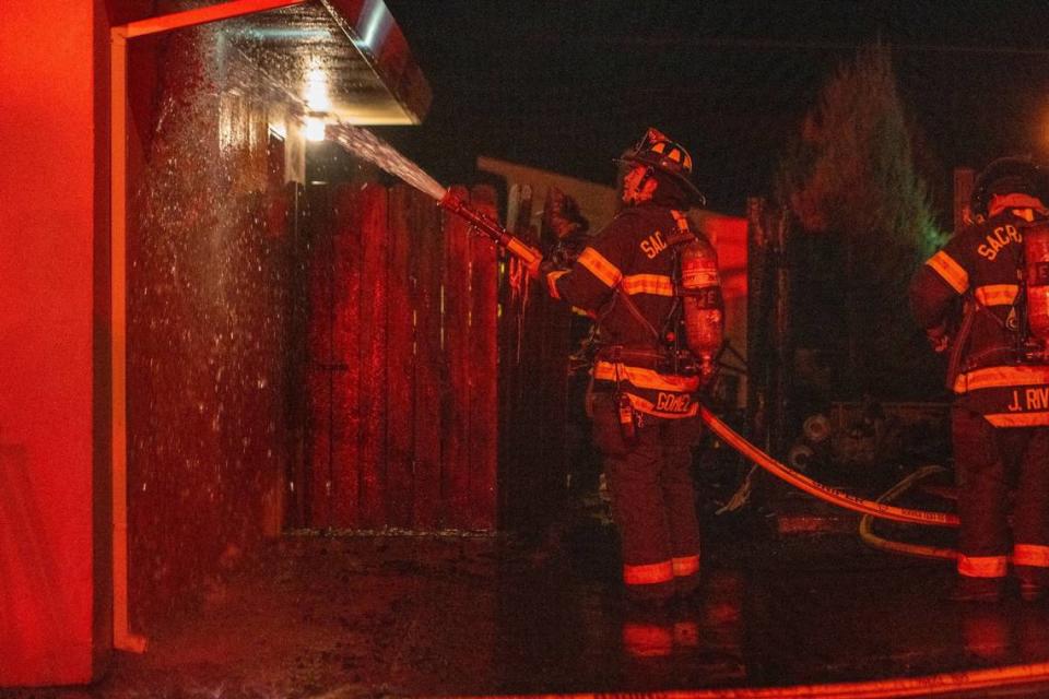 A Sacramento firefighter sprays water onto an exterior wall of a house involved in a structure fire on Piedmont Drive in Sacramento after the July Fourth holiday. The Sacramento Fire Department said fireworks were the likely cause of a fire that started between two homes on the street.