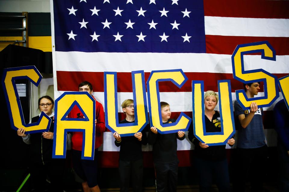 Attendees hold letters that read "CAUCUS" during a campaign event for Democratic presidential candidate former South Bend, Ind., Mayor Pete Buttigieg at Northwest Junior High, Sunday, Feb. 2, 2020, in Coralville, Iowa.