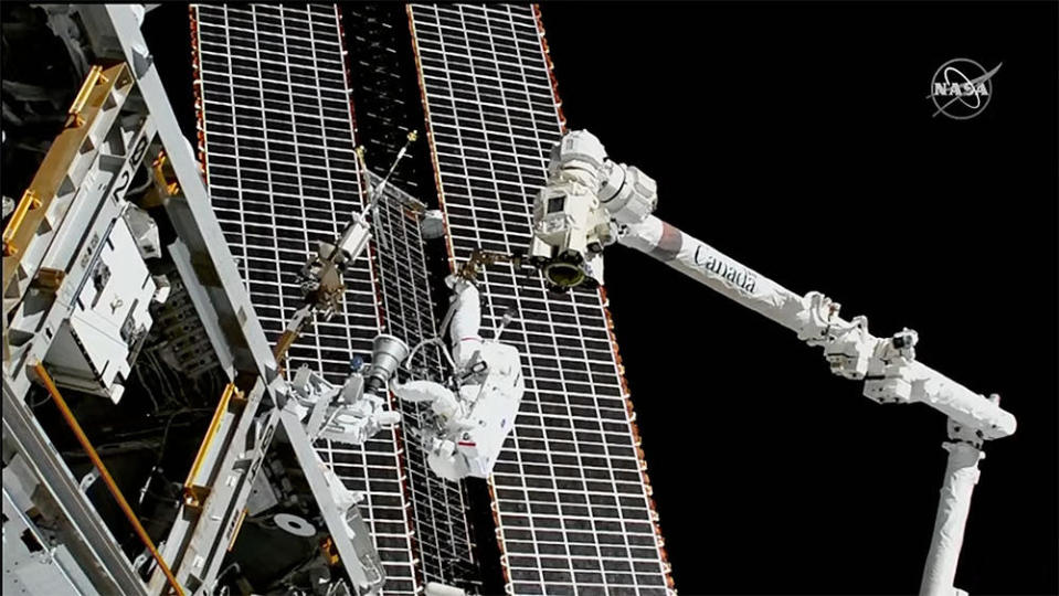 Veteran astronaut Thomas Marshburn, anchored to the end of the International Space Station's robot arm, inspects a newly installed S-basnd antenna assembly on the lab's power truss. / Credit: NASA TV