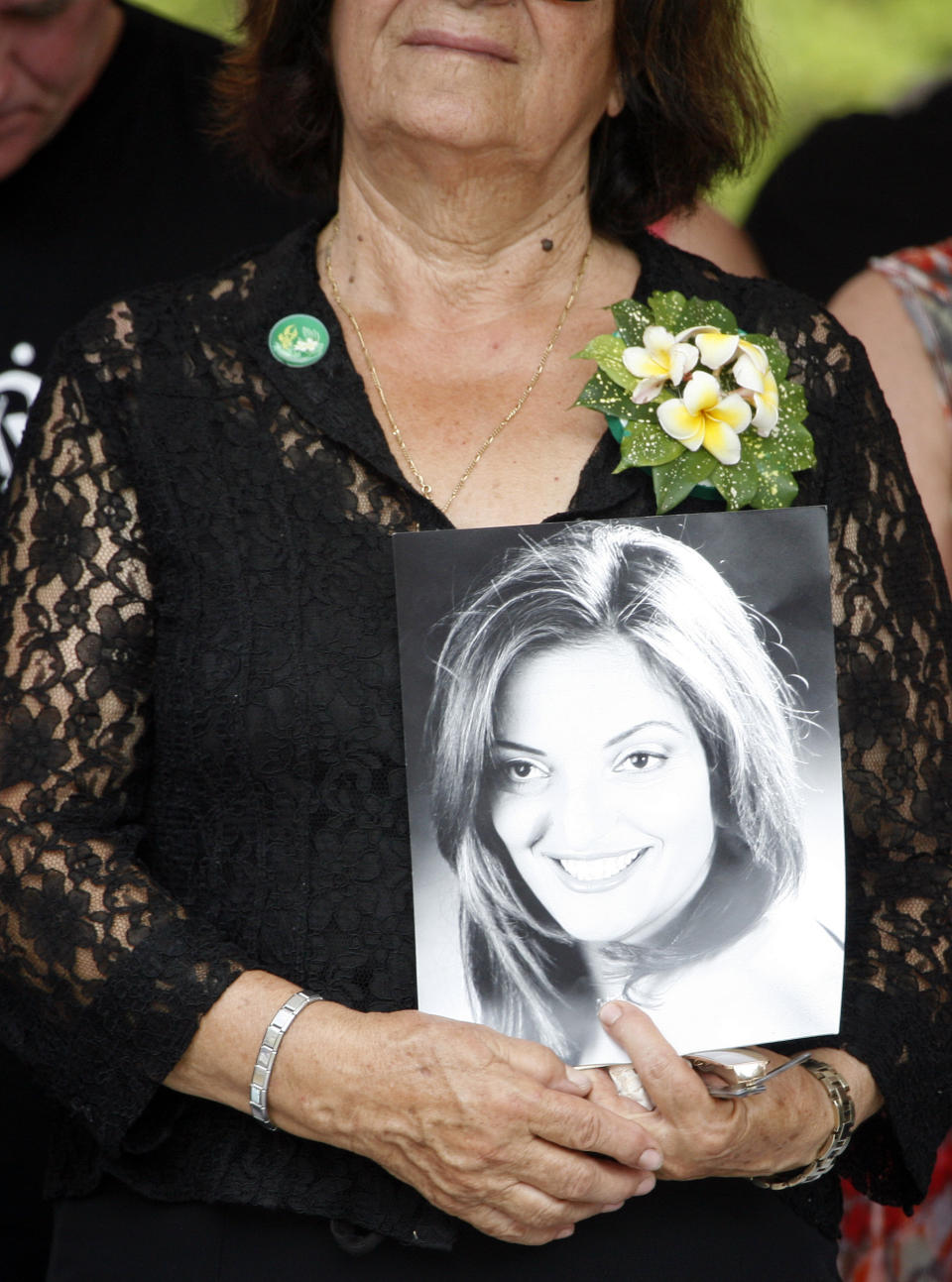 An Australian relative holds a photograph of the 2002 Bali bombings victim during a memorial service marking the 10th anniversary of the terrorist attacks at nightclubs in Kuta that killed 202 people, including 88 Australians and seven Americans, in Jimbaran in Bali, Indonesia, Friday, Oct. 12, 2012. (AP Photo/Made Nagi, Pool)