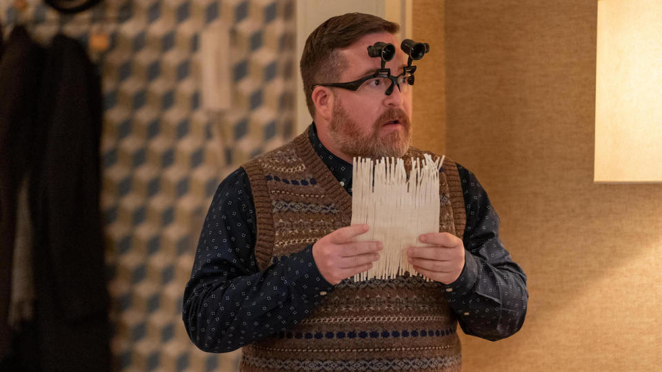 Michael Cyril Creighton holding put-together shredded document and wearing special glasses