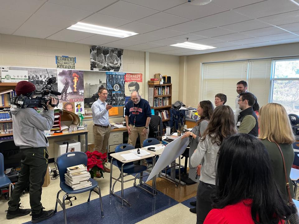 Former students surprised Brookfield East High School social studies teacher Patrick Coffey with a check for $16,500 and an alumni memory book.