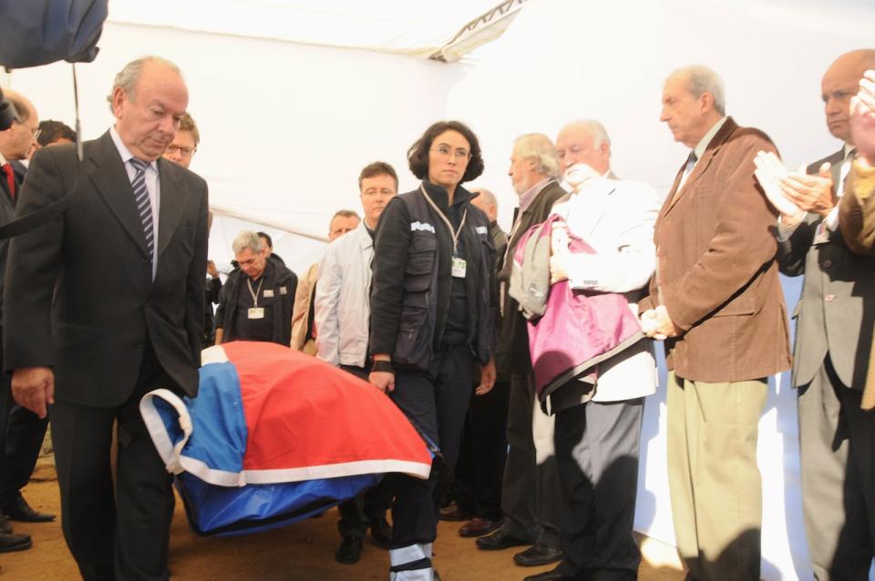 Rodolfo Reyes, left, grandnephew of Chilean poet and Nobel laureate Pablo Neruda, carries his coffin covered with the Chilean flag, on April 8,  2013, after it was exhumed. 