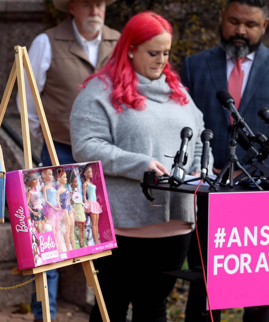 Maitlyn Gandy, mother of Athena Strand, speaks during a press conference with attorney Benson Varghese, right, on Thursday, Dec. 8, 2022, at the Wise County Courthouse in Decatur. Gandy presented the box, left, that was delivered by the FedEx driver on the day 7-year-old was abducted and killed. Inside was a Christmas present of Barbies for Athena..