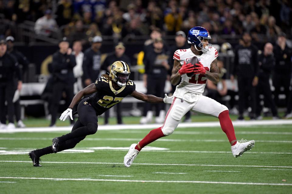 New York Giants tight end Darren Waller (12) catches a pass as New Orleans Saints cornerback Isaac Yiadom (27) defends during the first half of an NFL football game Sunday, Dec. 17, 2023, in New Orleans. (AP Photo/Matthew Hinton)