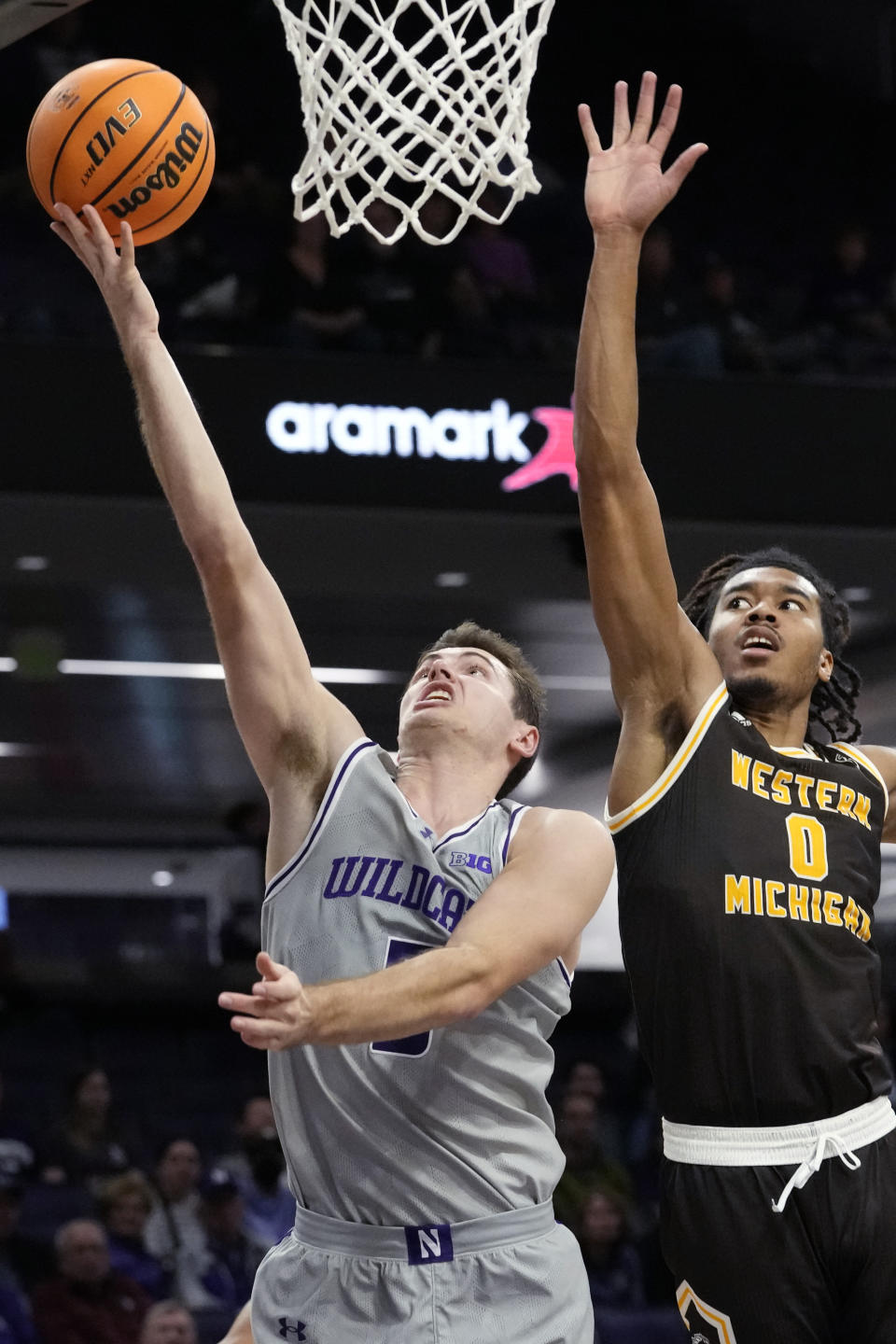 Northwestern guard Ryan Langborg, left, drives to the basket against Western Michigan forward Anthony Crump during the second half of an NCAA college basketball game in Evanston, Ill., Tuesday, Nov. 14, 2023. (AP Photo/Nam Y. Huh)