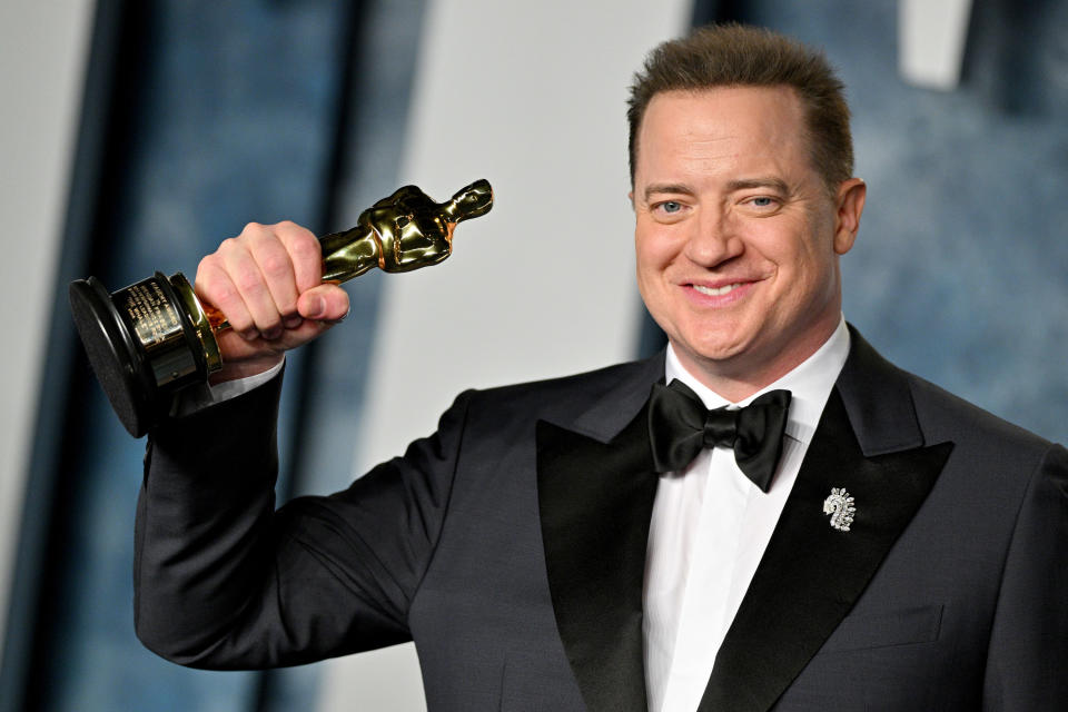 Brendan smiling in a bow tie and holding an Oscar