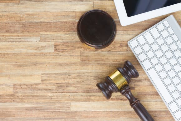 Gavel with a computer keyboard and tablet.