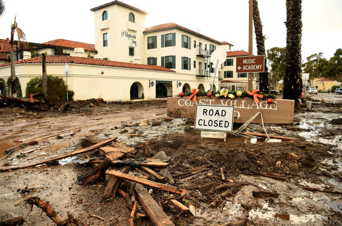 Mud and debris clog a road next to the Montecito Inn.