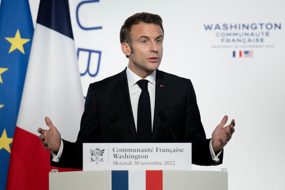 French president Emmanuel Macron holds a baguette as he speaks during a reception honoring the French community in the US, at the French Embassy in Washington, DC, on 30 November 2022 (AFP via Getty Images)