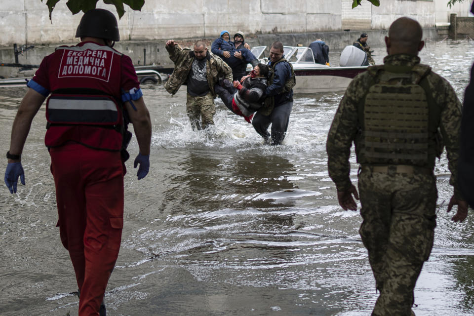 Emergency teams help rush to safety injured civilian evacuees who had came under fire from Russian forces while trying to flee by boat from the Russian-occupied east bank of a flooded Dnieper River to Ukrainian-held Kherson, on the western bank in Kherson, Ukraine on Sunday, June 11, 2023. (AP Photo)