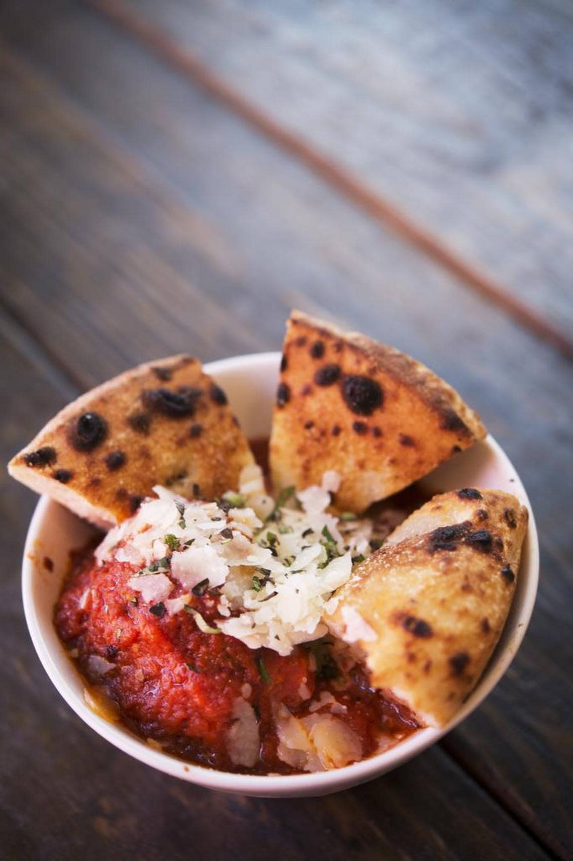 Cannonballs, meatballs with ground pork, ground beef and smoked meats covered in Italian grave topped with Shaved grand padding &fresh oregano, served at the Federalist Public House Wednesday June 3, 2015 in Sacramento. The Federalist Public House is a beer spot and pizza restaurant built from recycled shipping containers.