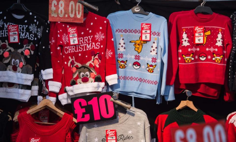 Christmas-themed jumpers for sale on a market stall