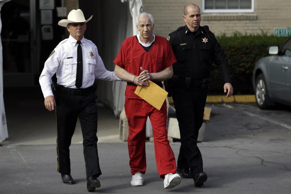 Former Penn State University assistant football coach Jerry Sandusky, center, is taken from the Centre County Courthouse by Centre County Sheriff Denny Nau, left, and a deputy, after being sentenced in Bellefonte, Pa., Tuesday, Oct. 9, 2012. Sandusky was sentenced to at least 30 years in prison, effectively a life sentence, in the child sexual abuse scandal that brought shame to Penn State and led to coach Joe Paterno's downfall. (AP Photo/Matt Rourke)