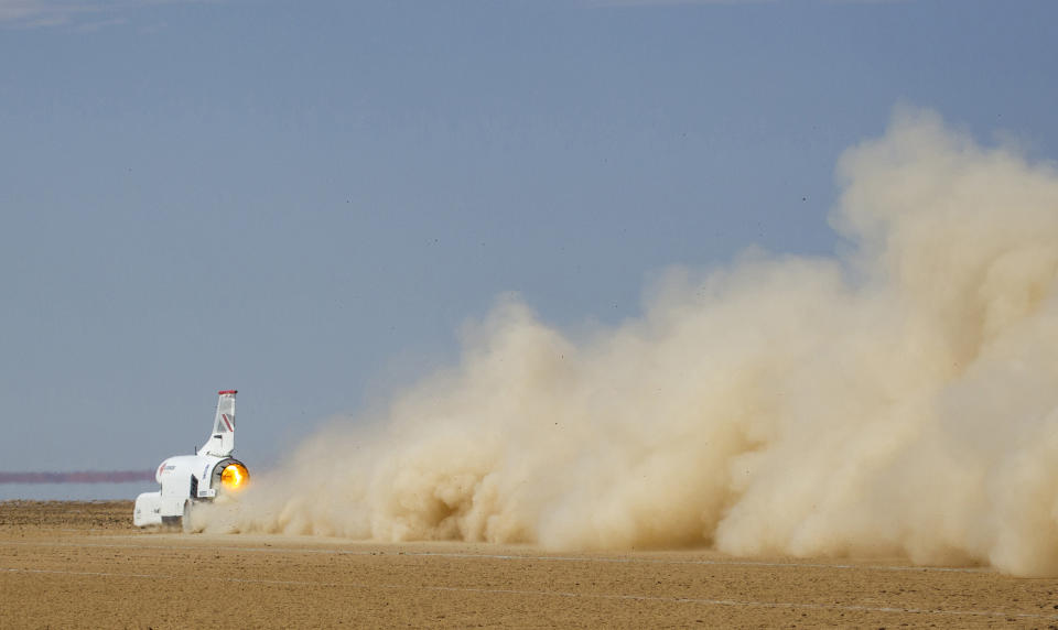 In this handout photo provided by Bloodhound, the vehicle speeds along the Hakskeenpan track in South Africa during trials to set a land speed record Friday, Nov. 8, 2019. Hitting 501 miles per hour on the South Africa’s northern desert, the Bloodhound became one of the world’s 10 fastest cars this week, on target for its goal to set a new land speed record. A jet that stays on earth, Bloodhound’s next goal is to reach 550 miles per hour, possibly in the coming week. (Charlie Sperring/Bloodhound via AP)