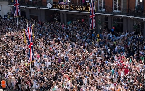 Crowds around 30 deep jostle for a view of the couple's procession - Credit: Eddie Mulholland for The Telegraph 