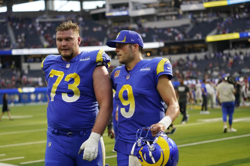 Los Angeles Rams quarterback Matthew Stafford walks off the field with offensive tackle David Edwards.