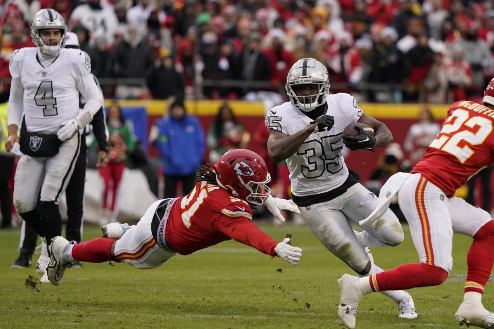 Las Vegas Raiders running back Zamir White (35) runs with the ball as Kansas City Chiefs defensive end Mike Danna (51) defends during the second half of an NFL football game Monday, Dec. 25, 2023, in Kansas City, Mo. (AP Photo/Ed Zurga)