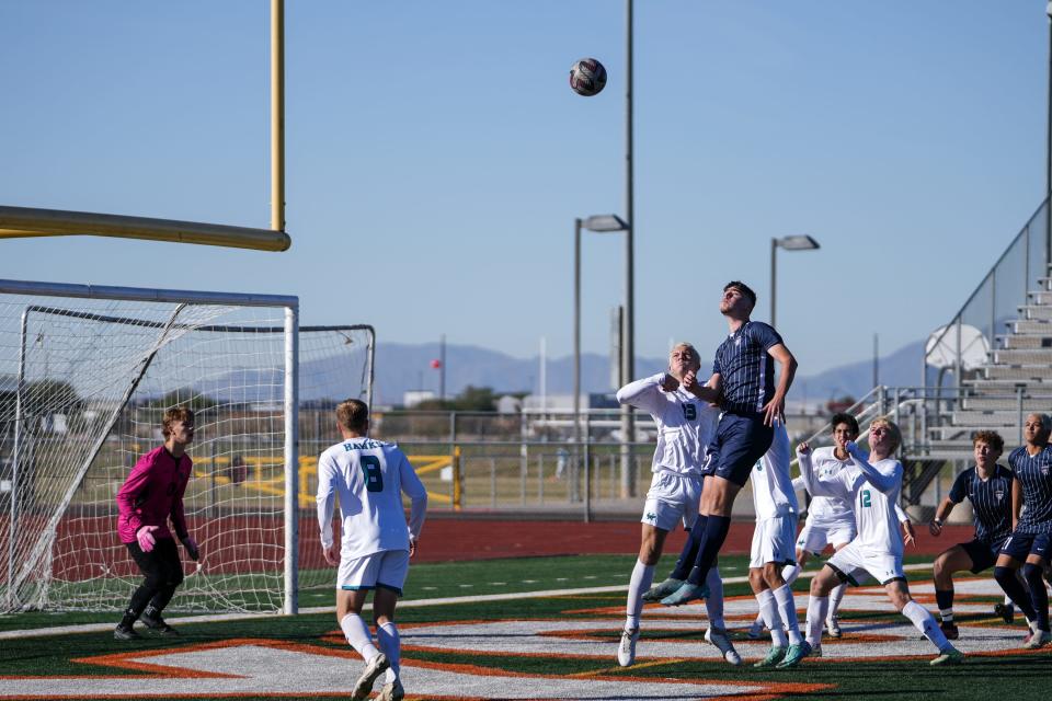 Highland High School’s Jackson O’Connor (13), left, and Perry High School’s ﻿Phoenix Berney (22), right, jump for the ball during the first half of the Coyote Classic Tournament 6A division semi-finals at Campo Verde High School in Gilbert on Dec. 9, 2023.
