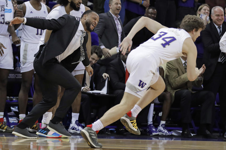 Washington assistant coach Will Conroy, left, celebrates on the bench after forward Reagan Lundeen (34) tipped in a shot against California during the second half of an NCAA college basketball game Saturday, Feb. 22, 2020, in Seattle. Washington won 87-52. (AP Photo/Ted S. Warren)