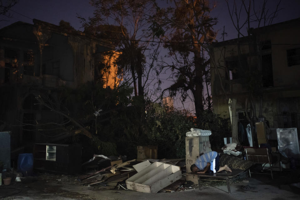 Mohammed Moussa prays on a makeshift bed outside his home, destroyed in the Aug. 4 explosion, in Beirut, Lebanon, on Sunday, Aug. 16, 2020. (AP Photo/Felipe Dana)